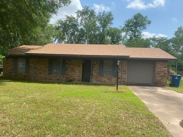 ranch-style home featuring an attached garage, a front yard, driveway, and brick siding