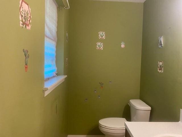 bathroom with toilet, baseboards, and vanity