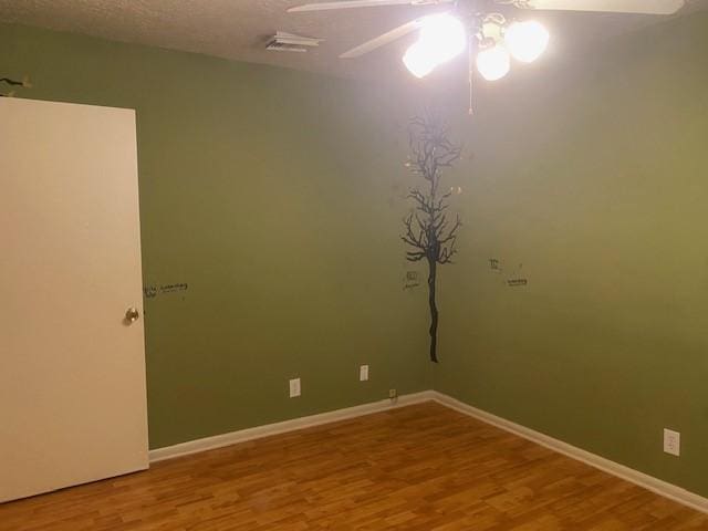 empty room with baseboards, a ceiling fan, and wood finished floors