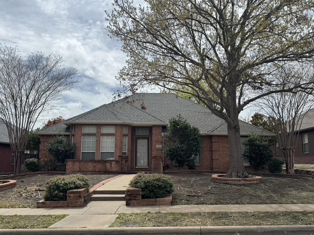 view of front of home with brick siding and a shingled roof
