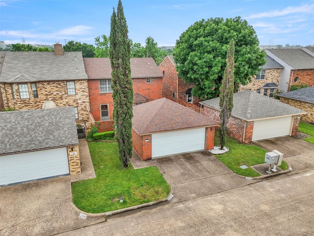 view of front of property featuring a residential view, brick siding, a garage, a front yard, and a chimney
