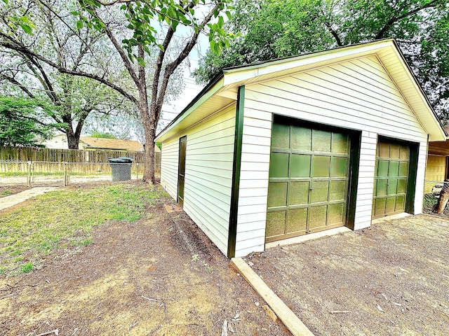 detached garage featuring fence