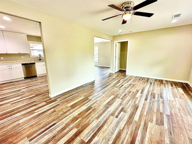 unfurnished living room featuring a ceiling fan, baseboards, visible vents, and light wood-type flooring