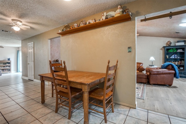 dining area featuring a textured wall, ceiling fan, tile patterned flooring, a textured ceiling, and visible vents