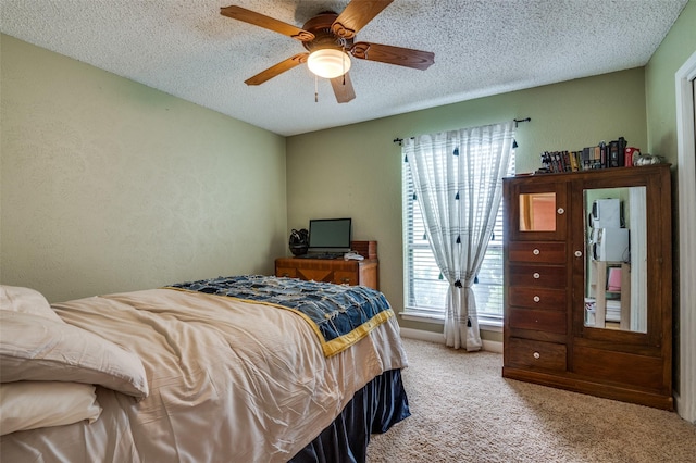 carpeted bedroom featuring a textured ceiling and a ceiling fan