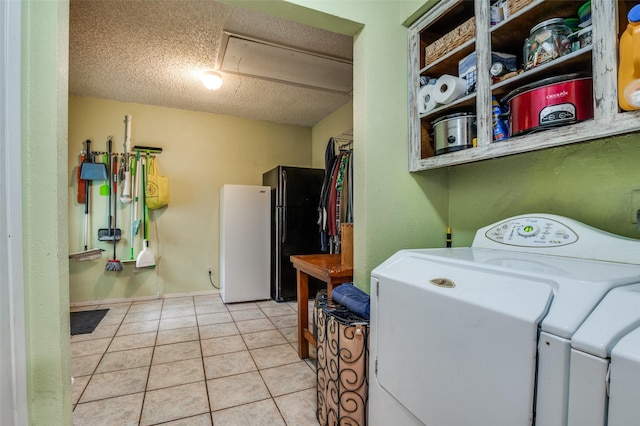 laundry area with attic access, a textured ceiling, light tile patterned floors, and washing machine and dryer
