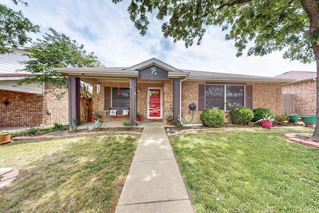 ranch-style house with brick siding, covered porch, and a front yard