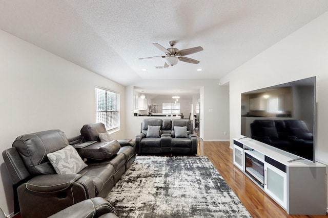living area with light wood-style floors, a ceiling fan, baseboards, recessed lighting, and visible vents