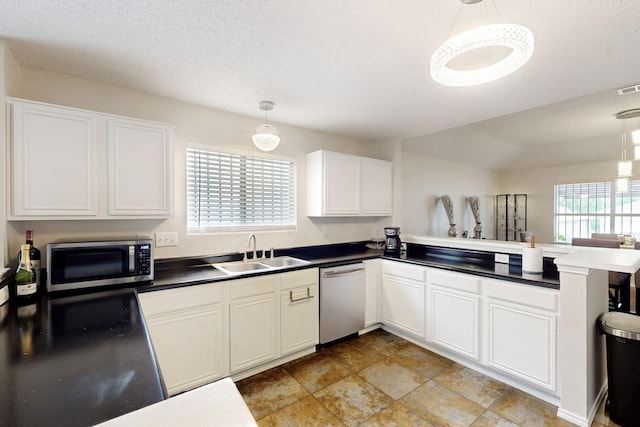 kitchen featuring a peninsula, white cabinetry, a sink, hanging light fixtures, and stainless steel appliances