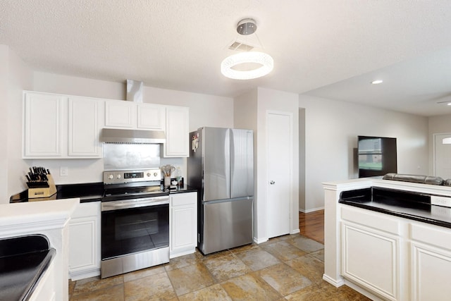 kitchen featuring dark countertops, open floor plan, under cabinet range hood, white cabinets, and appliances with stainless steel finishes
