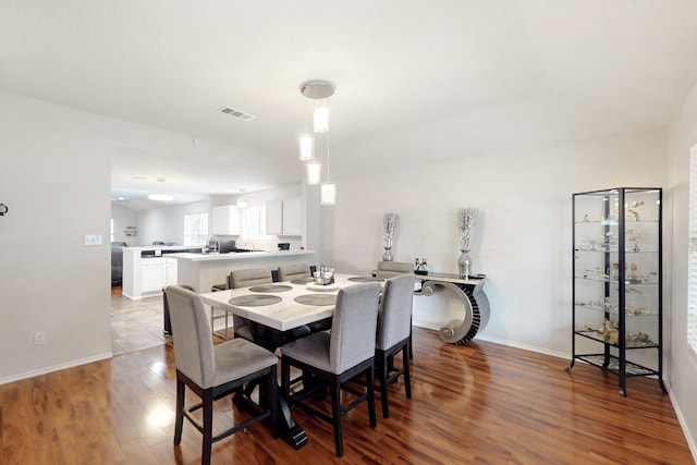 dining room featuring baseboards, wood finished floors, and visible vents