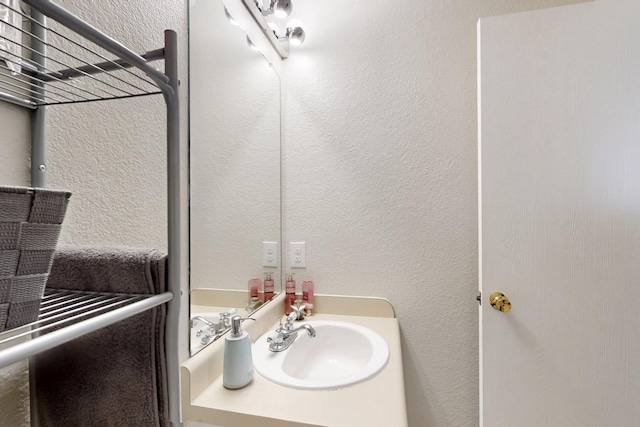 bathroom with vanity and a textured wall