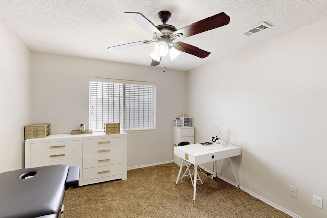 home office featuring visible vents, baseboards, ceiling fan, light colored carpet, and a textured ceiling