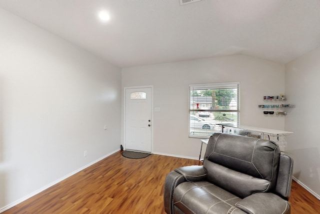 living area featuring light wood-type flooring, baseboards, and vaulted ceiling