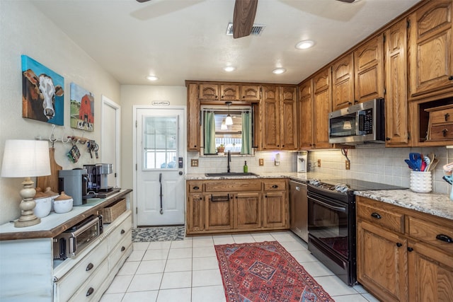 1076 N Cedar St, Muenster, TX 76252 - kitchen featuring a sink, decorative backsplash, stainless steel appliances, and brown cabinets