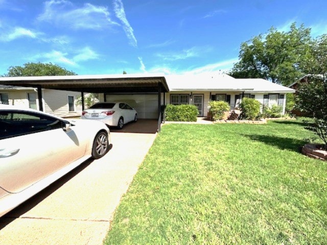 ranch-style home featuring a carport, an attached garage, driveway, and a front lawn