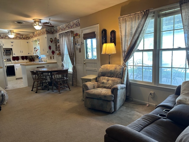 living area featuring plenty of natural light and light carpet