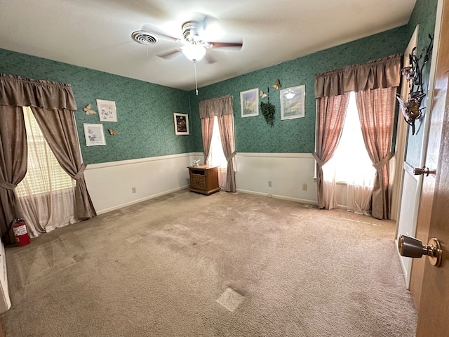 unfurnished bedroom with visible vents, a ceiling fan, and carpet