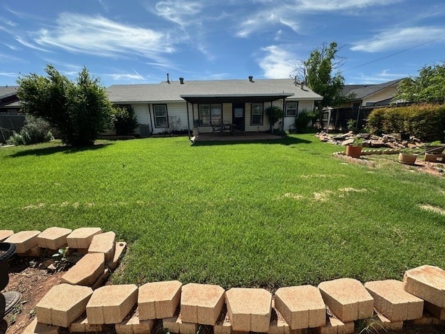 rear view of house featuring a yard and a sunroom