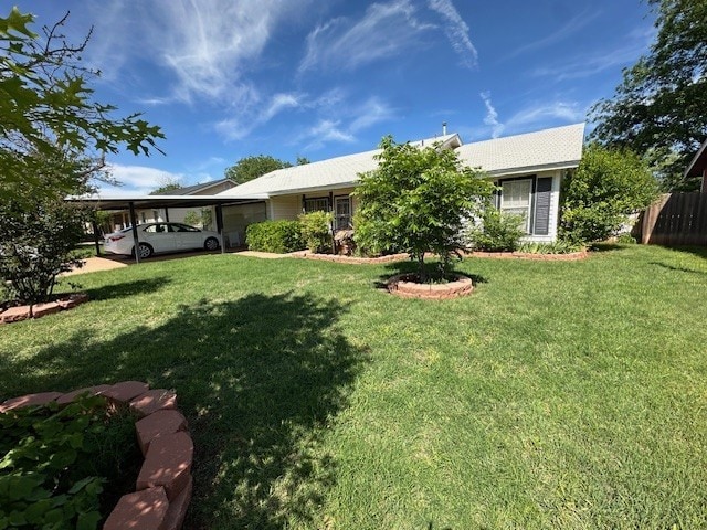 back of house featuring a garage, fence, and a lawn