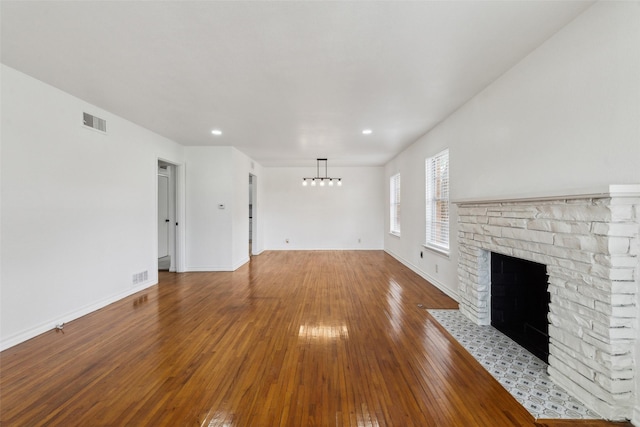 2136 Van Cleave Dr, Dallas, TX 75216 - unfurnished living room featuring a chandelier, hardwood / wood-style floors, baseboards, a fireplace with flush hearth, and visible vents