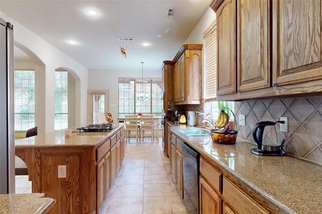 kitchen featuring a wealth of natural light, a sink, black appliances, and a center island