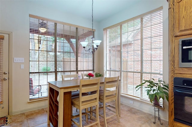 dining room featuring baseboards, light tile patterned floors, a notable chandelier, and a wealth of natural light