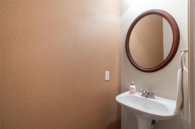bathroom featuring a sink and a textured wall