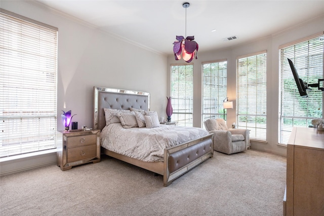 bedroom with multiple windows, ornamental molding, and light colored carpet