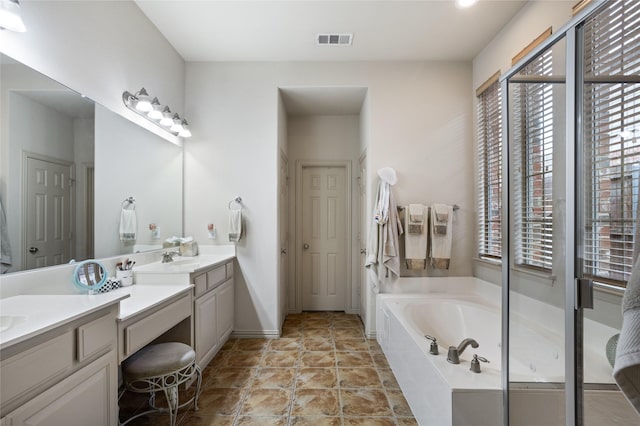 full bathroom featuring baseboards, visible vents, a garden tub, and vanity