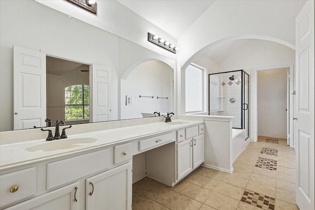 full bath with double vanity, a shower stall, a sink, and tile patterned flooring