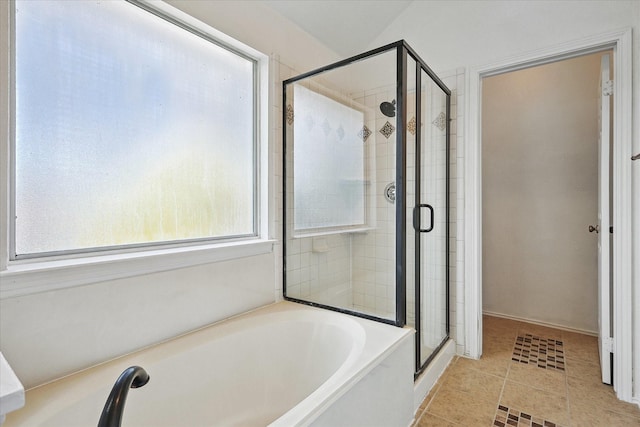 bathroom featuring a shower stall and a bath