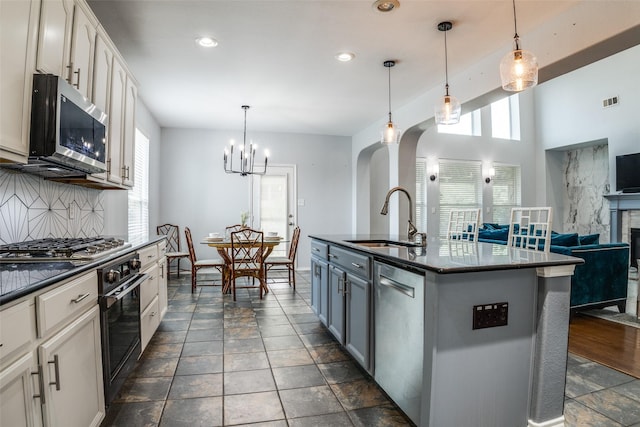 10228 Crawford Farms Dr, Fort Worth, TX 76244 - kitchen with a sink, appliances with stainless steel finishes, arched walkways, backsplash, and open floor plan