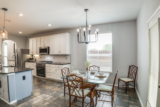 10228 Crawford Farms Dr, Fort Worth, TX 76244 - kitchen featuring appliances with stainless steel finishes, dark countertops, tasteful backsplash, recessed lighting, and arched walkways