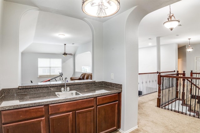 10228 Crawford Farms Dr, Fort Worth, TX 76244 - kitchen featuring a sink, arched walkways, carpet flooring, a ceiling fan, and hanging light fixtures
