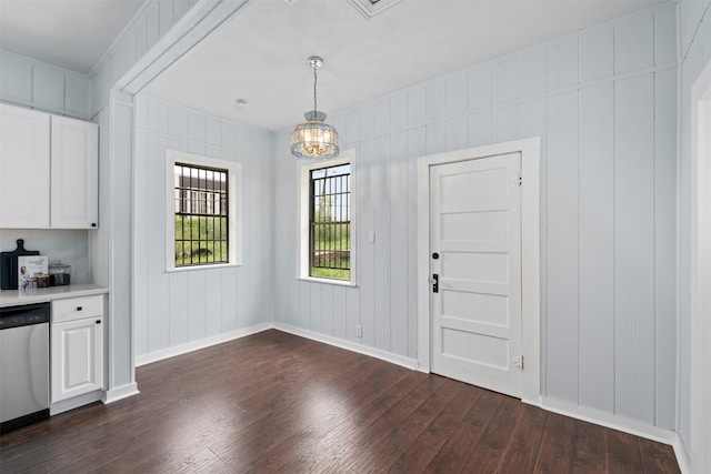 2124 21st St, Fort Worth, TX 76164 - unfurnished dining area with dark wood-style flooring, baseboards, a chandelier, and a decorative wall