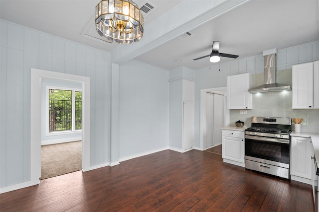 2124 21st St, Fort Worth, TX 76164 - kitchen with stainless steel gas stove, wall chimney exhaust hood, dark wood-type flooring, light countertops, and white cabinetry