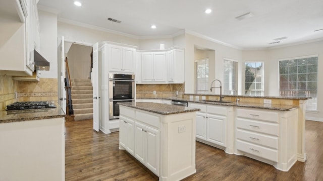 708 Renaissance Ct, Keller, TX 76248 - kitchen with a sink, a peninsula, stainless steel appliances, visible vents, and decorative backsplash