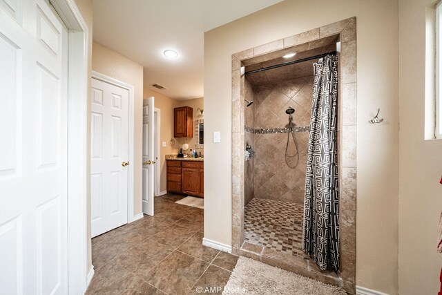 3756 County Road 192, Anson, TX 79501 - full bathroom featuring visible vents, vanity, baseboards, tile patterned floors, and tiled shower