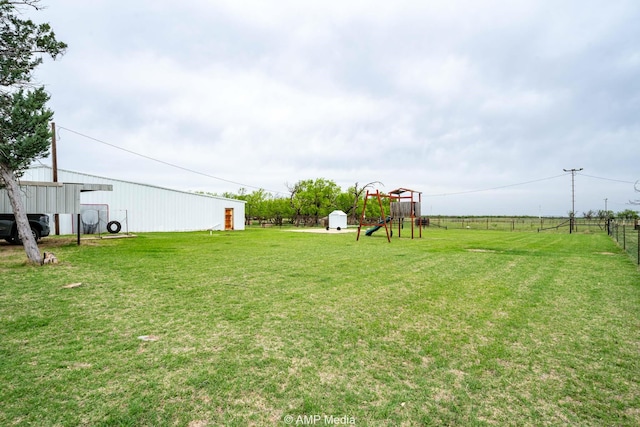 3756 County Road 192, Anson, TX 79501 - view of yard featuring a pole building, a playground, fence, and an outbuilding