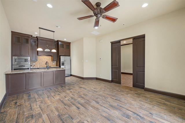 kitchen featuring a ceiling fan, visible vents, appliances with stainless steel finishes, tasteful backsplash, and wood finished floors