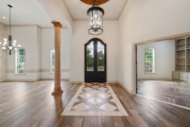 entryway featuring an inviting chandelier, arched walkways, french doors, and a towering ceiling