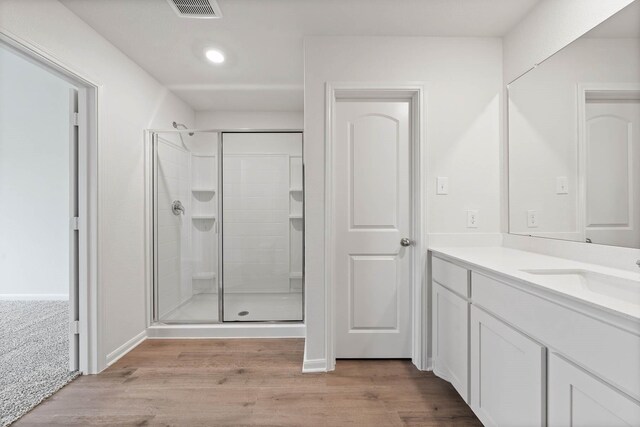 bathroom with vanity, recessed lighting, a shower stall, wood finished floors, and visible vents