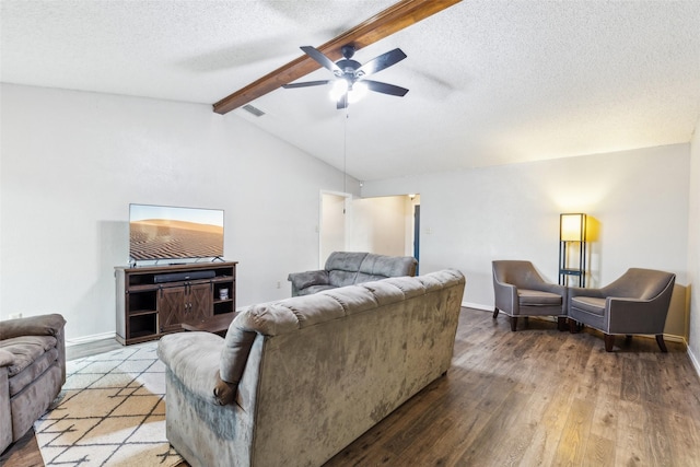 living room featuring ceiling fan, a textured ceiling, baseboards, vaulted ceiling with beams, and hardwood / wood-style floors