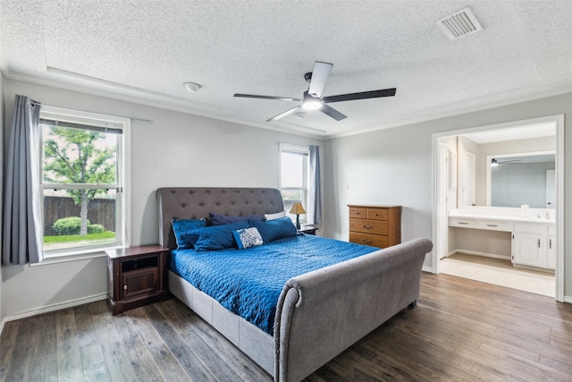 bedroom featuring a ceiling fan, a textured ceiling, visible vents, hardwood / wood-style flooring, and connected bathroom