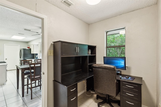 office area with light tile patterned flooring, a textured ceiling, and visible vents