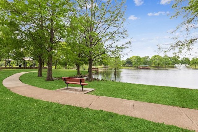 surrounding community with a water view and a yard