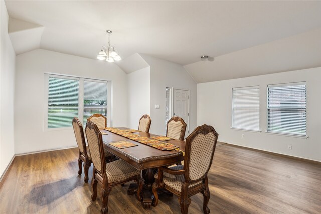 dining space featuring vaulted ceiling, a chandelier, dark wood-style flooring, and healthy amount of natural light