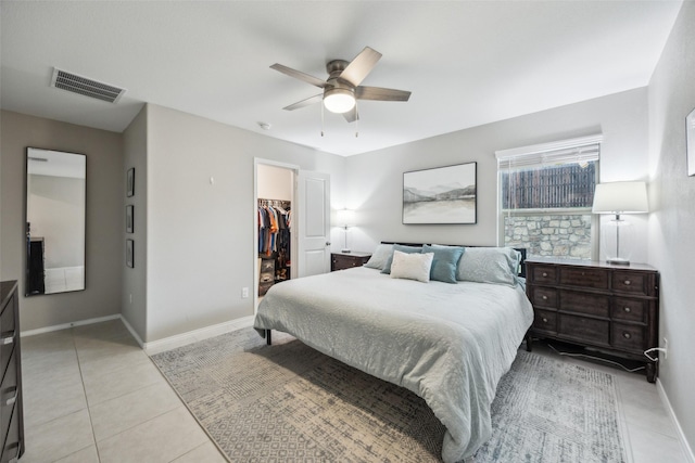 bedroom with light tile patterned flooring, baseboards, a spacious closet, visible vents, and a closet