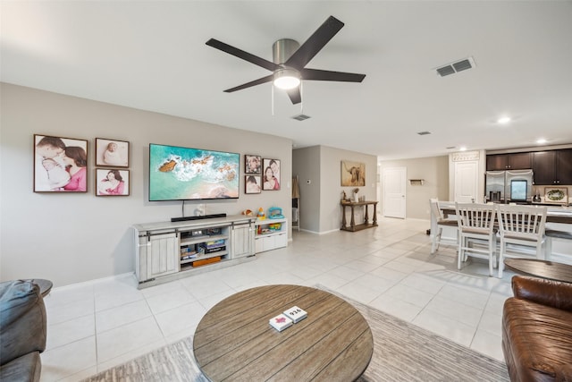 living room featuring visible vents, a ceiling fan, baseboards, and light tile patterned floors